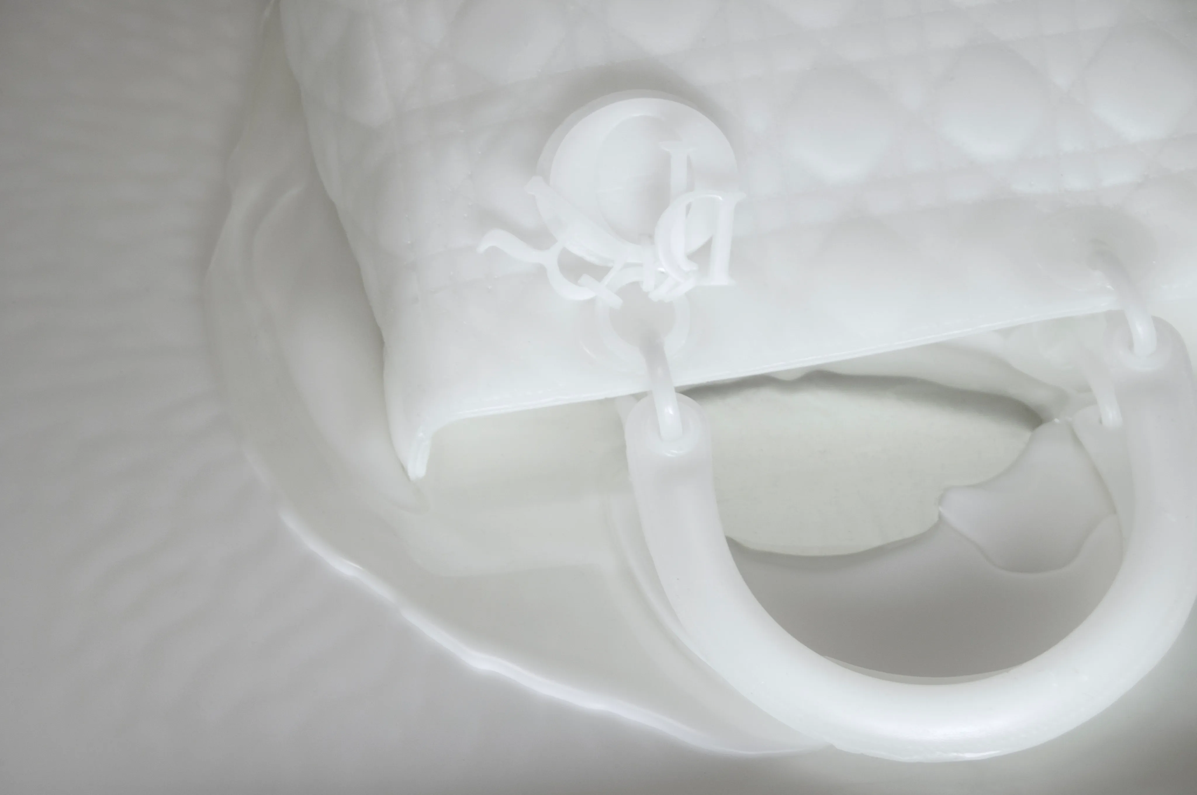 Behind the scenes: the wax Lady Dior bag mid-melt on the heating plate during filming.